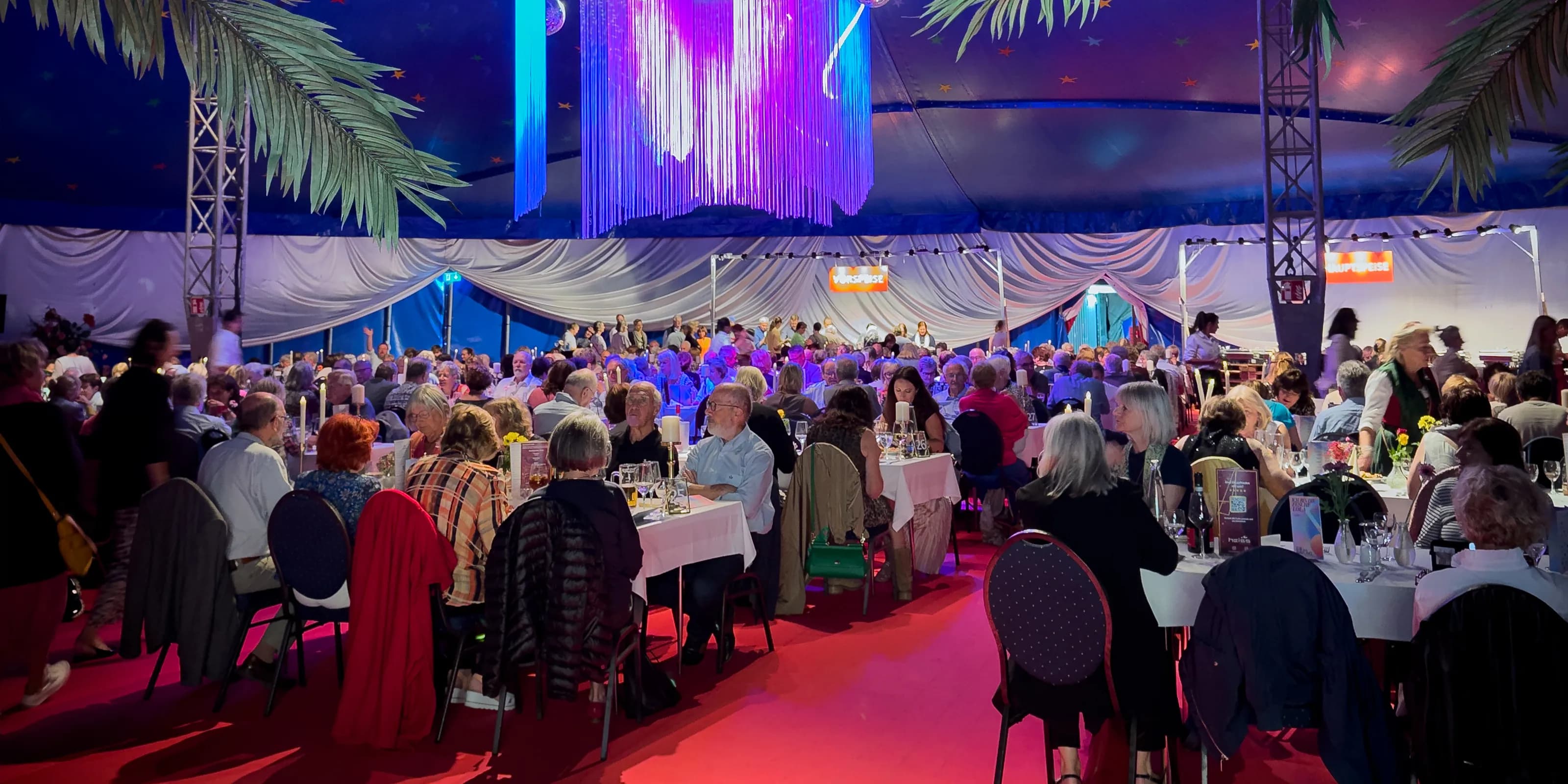 Veranstaltung mit gefüllten Esstischen